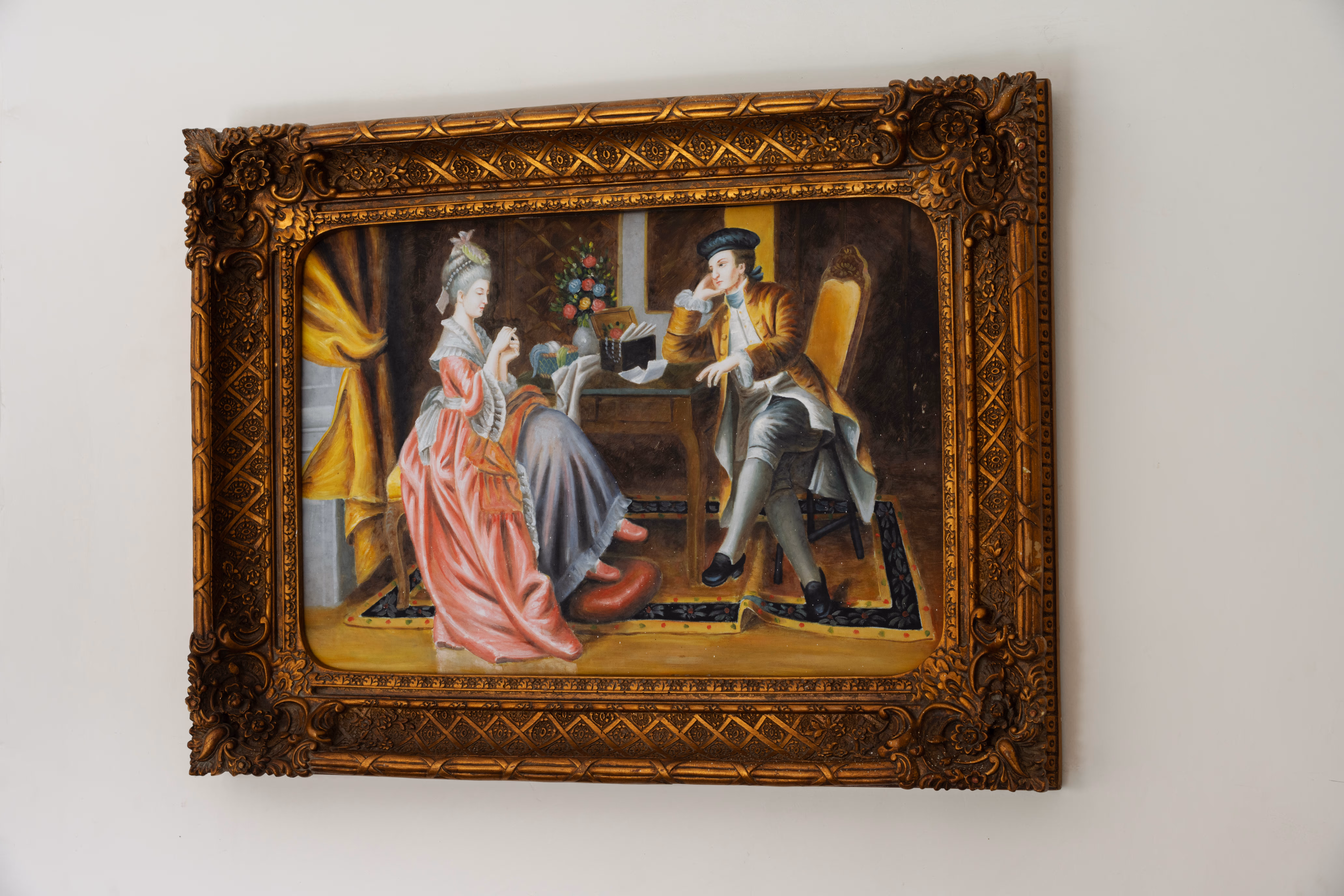 Framed figurative painting in an ornate gold frame displayed on a cream palace wall.